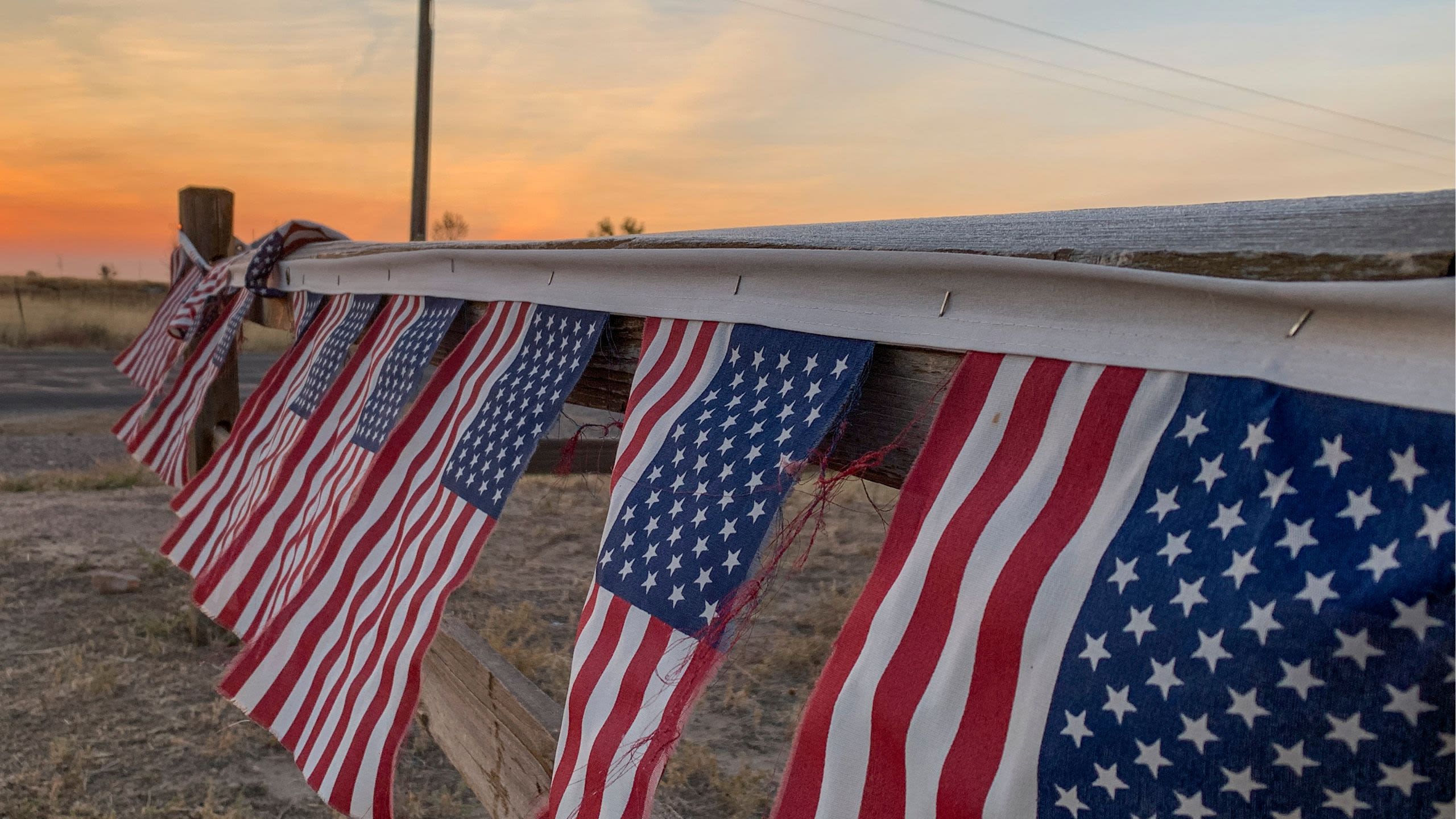 American flags hanging on a fence by Barr Lake.