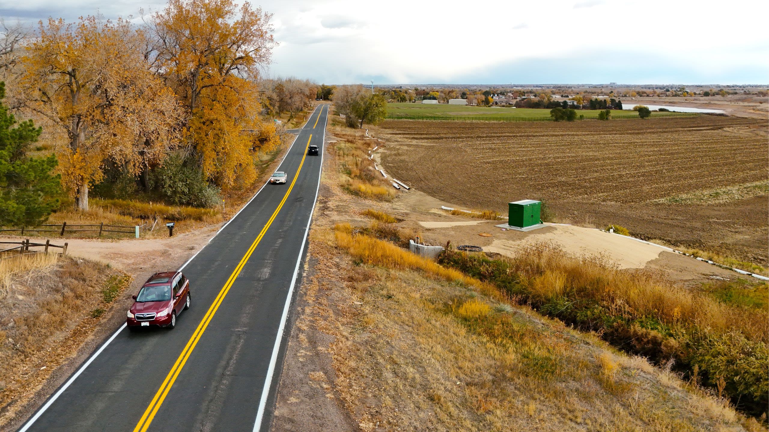 Several cars driving down Riverdale Road in Adams County, with fall colors in the surrounding landscape.